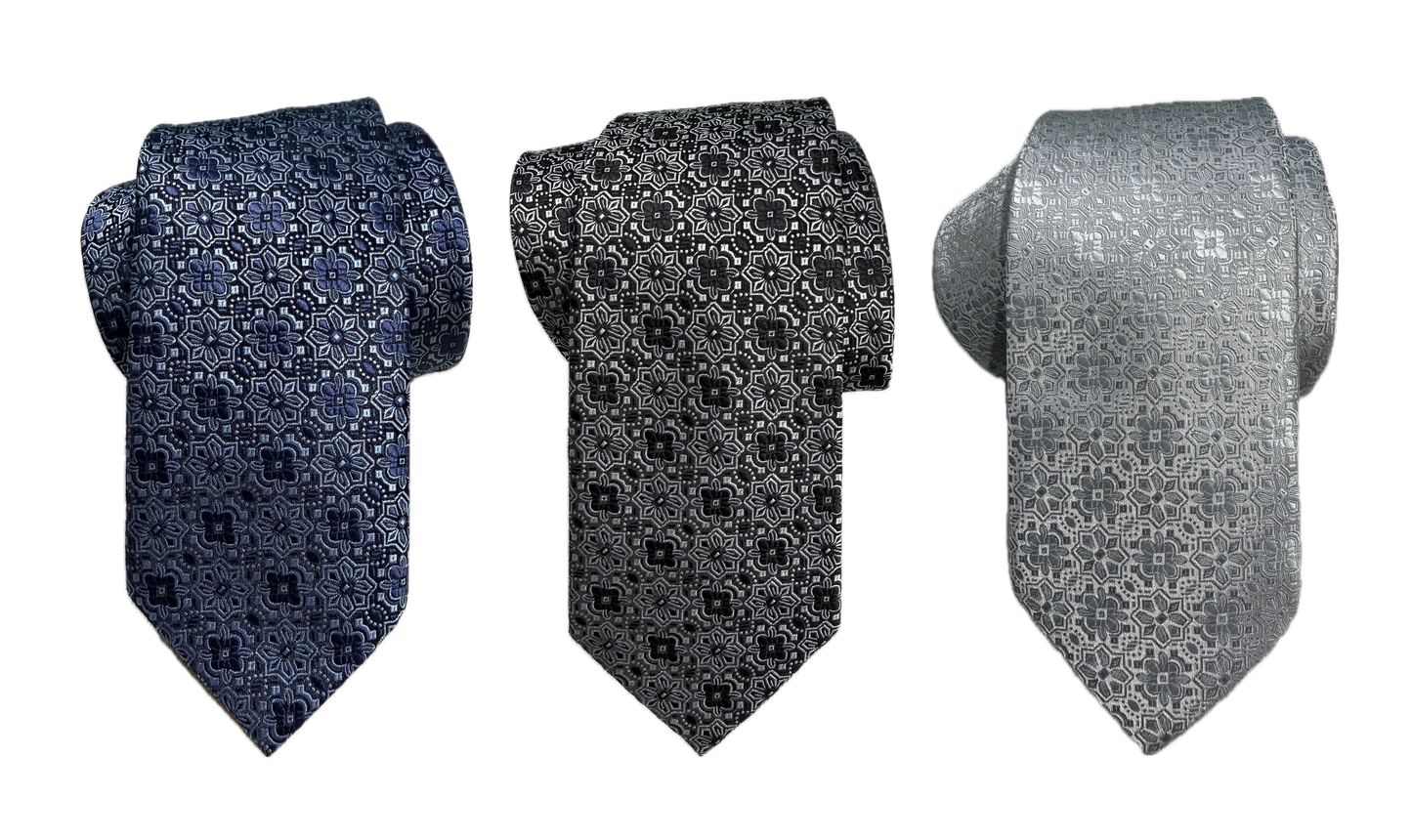 Three rolled floral medallion-patterned ties in blue, black, and gray on a white background